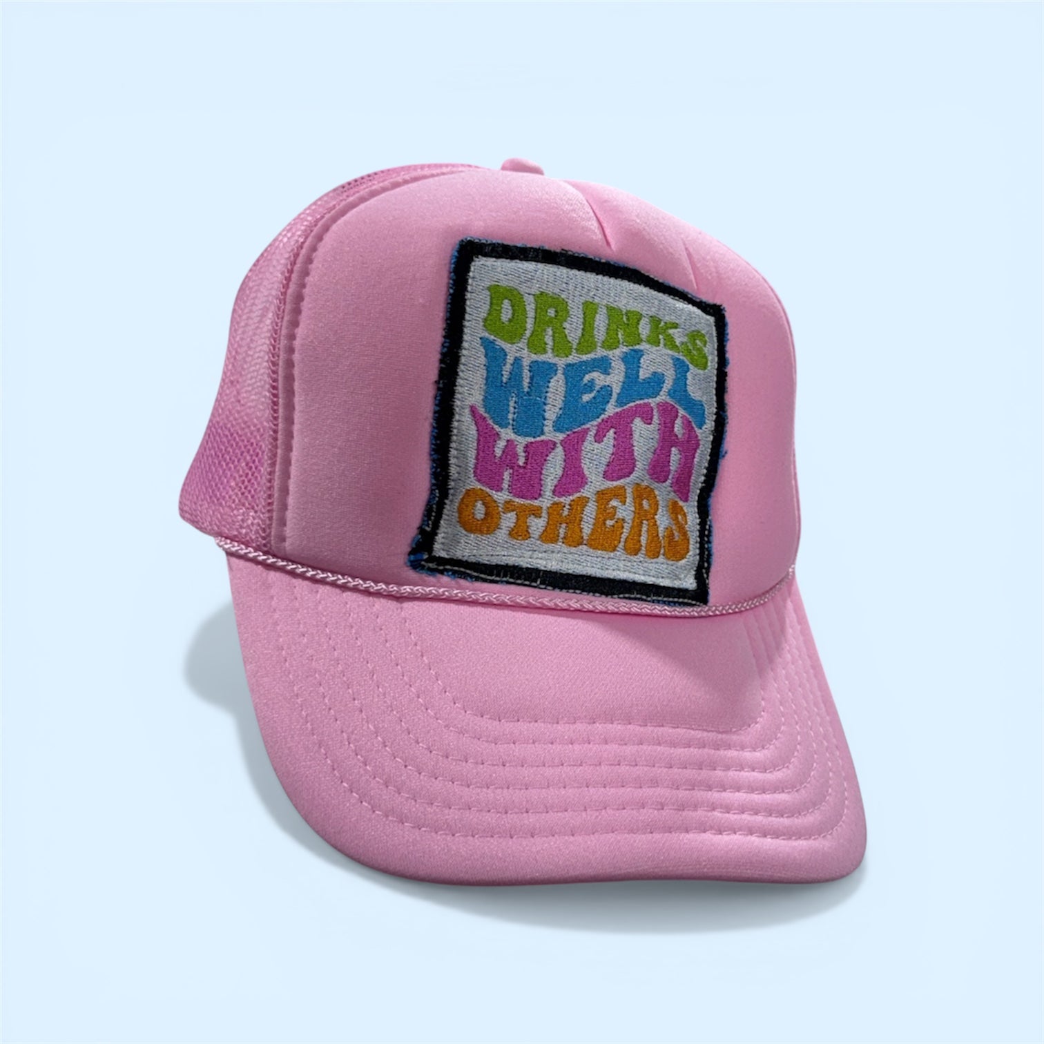 Pink cap with a colorful patch on a light blue background