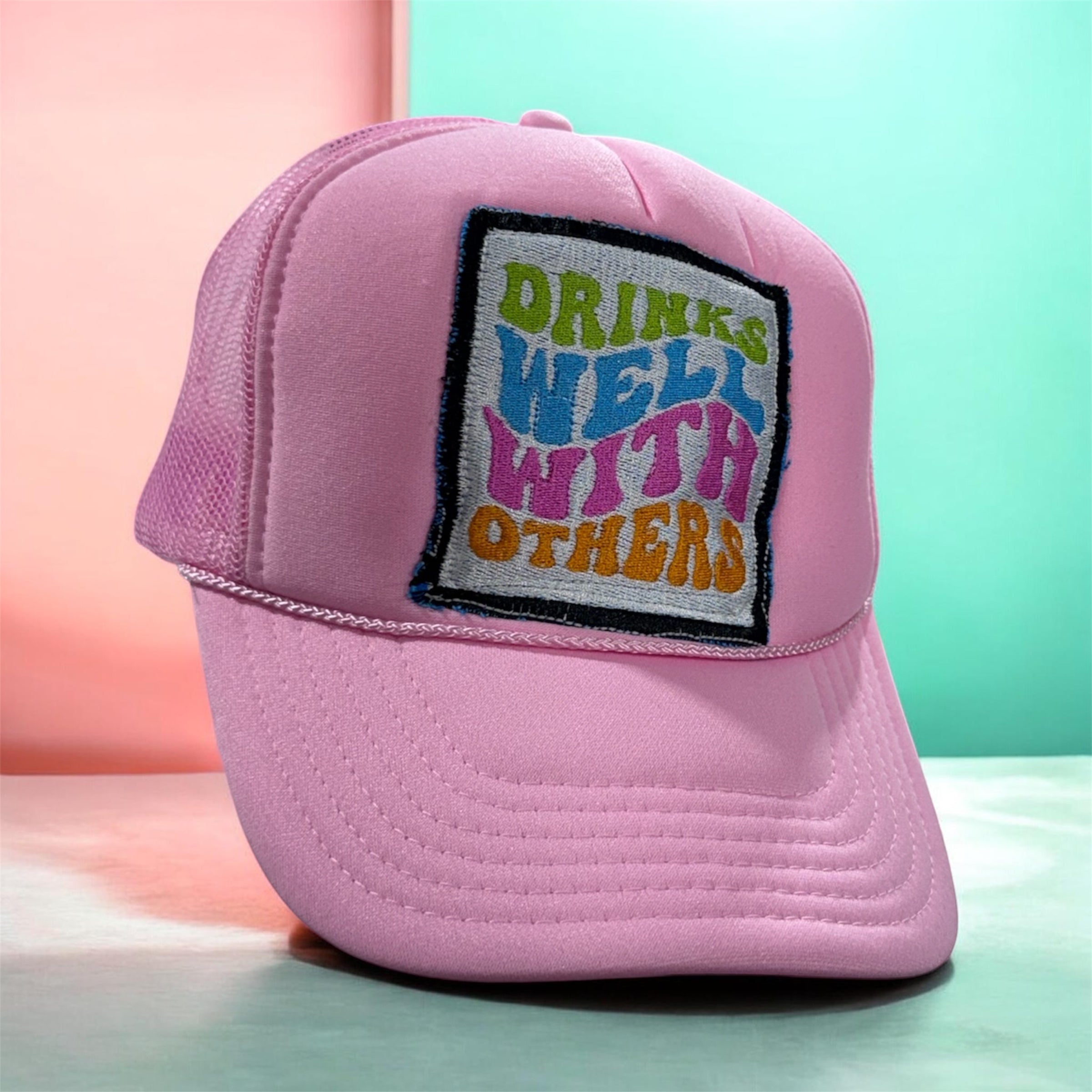 Pink cap with colorful patch on a pastel background